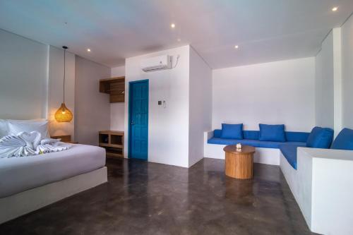 a bedroom with a bed and a blue couch at Sunset Paradise Canggu in Canggu