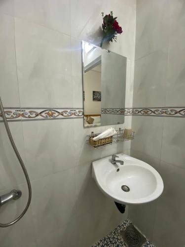 a white bathroom with a sink and a mirror at Tấn Đạt Hotel Quy Nhơn in Quy Nhon