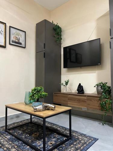 a living room with a table and a tv on a wall at 1 Precioso Departamento en Barrio Antiguo in Monterrey