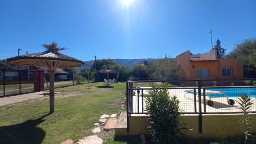 a patio with an umbrella next to a swimming pool at Cabaña Sombra Lunar en Cabañas Encuentro in Carpintería