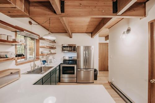 a kitchen with stainless steel appliances and wooden ceilings at Glacier Springs Cabin 27 - A private 2-story cabin pet-friendly in Deming
