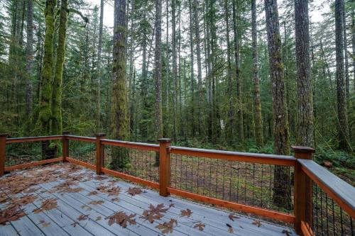 a wooden deck with a view of the forest at Glacier Springs Cabin 12 - Pet Friendly, WIFI, AC, Sleeps 4 in Deming