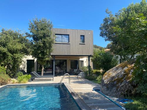 une maison avec une piscine devant dans l'établissement Pavillon de la Trinité, à Porto-Vecchio