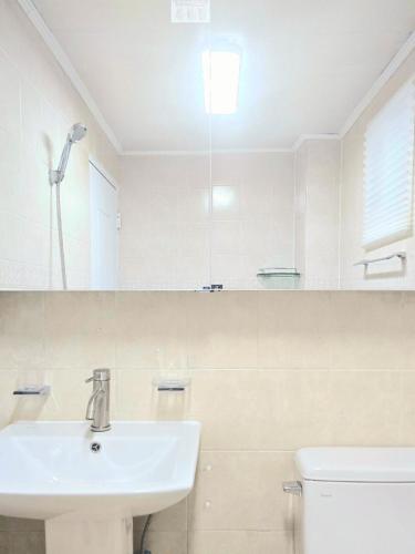 a white bathroom with a sink and a toilet at feel at Home in Incheon