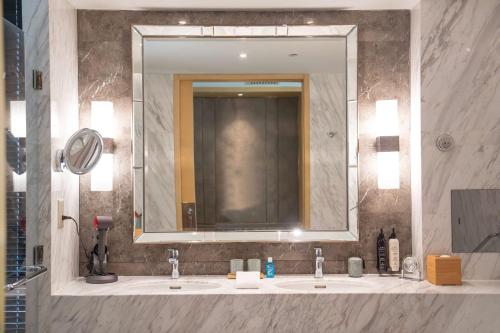 a bathroom with two sinks and a large mirror at Midtown Shangri-La, Hangzhou - around 5 minutes walking distance to West Lake in Hangzhou