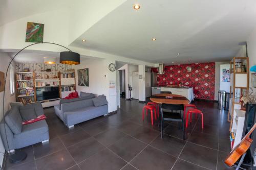 un salon avec un canapé, une table et des chaises dans l'établissement Maison jardin proximité plage, à Duingt