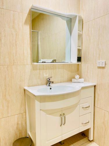 a bathroom with a white sink and a mirror at Parklane Motel Murray Bridge in Murray Bridge
