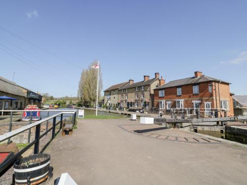 a view of a canal with houses and buildings at 3 Canalside Cottages in Towcester