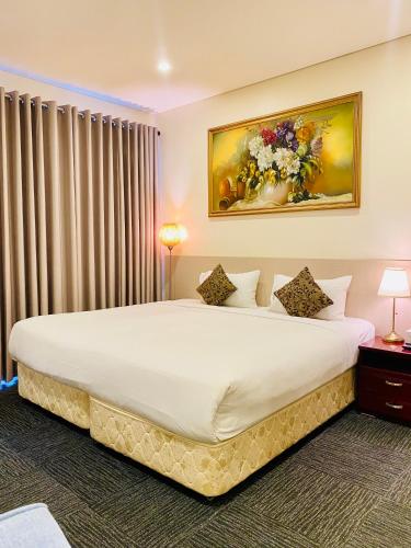 a bedroom with a large bed with a painting on the wall at Parklane Motel Murray Bridge in Murray Bridge