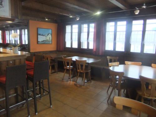ein Esszimmer mit Tischen, Stühlen und Fenstern in der Unterkunft Hotel Weisshorn in Ritzingen