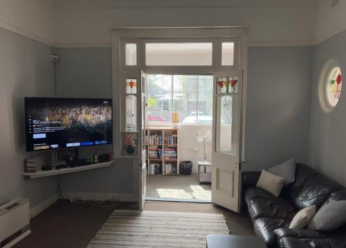 a living room with a television and a couch at Manly Bunkhouse in Sydney