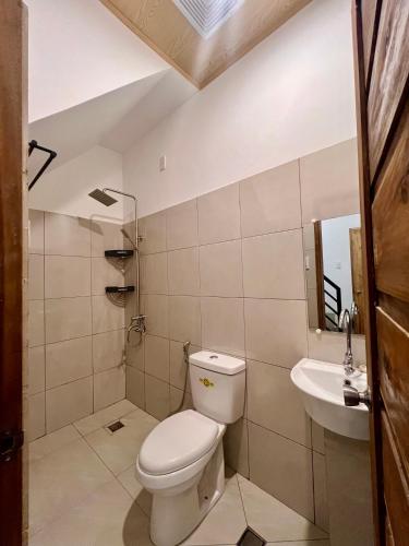 a bathroom with a toilet and a sink at Cozy Family Studio - Ronaldos Inn Twinex Suite in General Luna