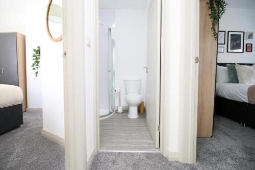 a bedroom with a bathroom with a toilet and a bed at Cohost Partners Charming 3BR Near City Centre Parking in Newport
