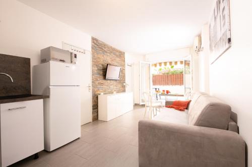 un salon avec un canapé et une cuisine dans l'établissement le Victoria, centre ville , plage et parking gratuit, à Sainte-Maxime