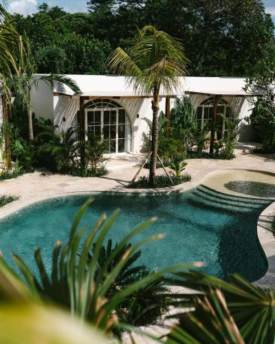a house with a swimming pool and a building at Mayiki Boutique Hotel in Uluwatu