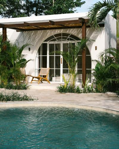 a house with a swimming pool in front of a house at Mayiki Boutique Hotel in Uluwatu