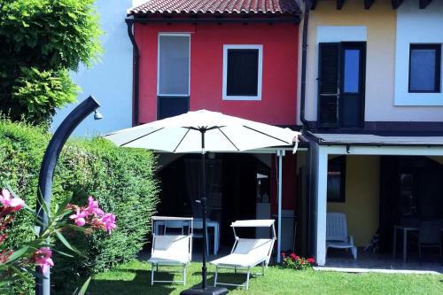 an umbrella and chairs in the yard of a house at Casa 951 in Caleri