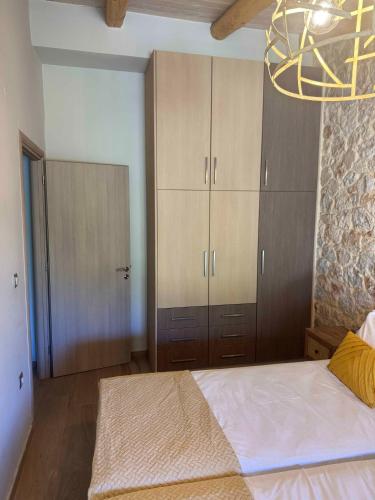 a bedroom with a large bed and wooden cabinets at Skandalis Apartments with pool in Chorafakia