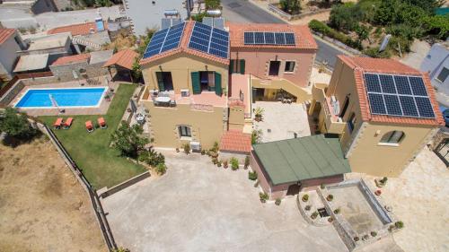 an aerial view of a house with solar panels on the roof at Skandalis Apartments with pool in Chorafakia