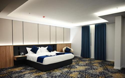a bedroom with a large bed with blue and white pillows at Elite Haven in Al Madinah
