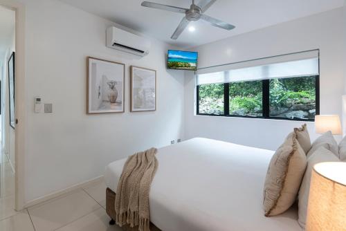a white bedroom with a bed and a window at Pinnacle Apartments on Hamilton Island by HIHA in Hamilton Island