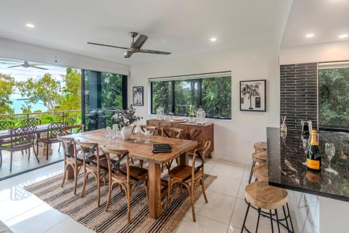 a dining room with a wooden table and chairs at Pinnacle Apartments on Hamilton Island by HIHA in Hamilton Island