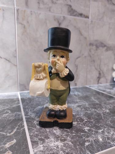 a figurine with a top hat holding a piece of bread at Balkan Tower Deluxe Candy in Gabrovo