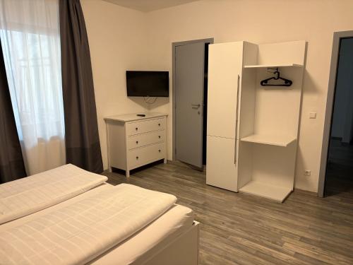 a bedroom with two beds and a tv and a dresser at Hotel-Fritz in Valwig