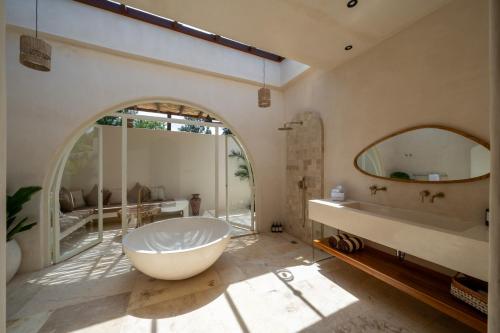 a bathroom with a large tub and a large mirror at Mayiki Boutique Hotel in Uluwatu