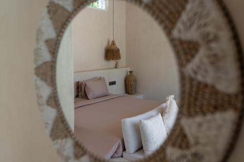 a mirror reflection of a bed in a room at Mayiki Boutique Hotel in Uluwatu