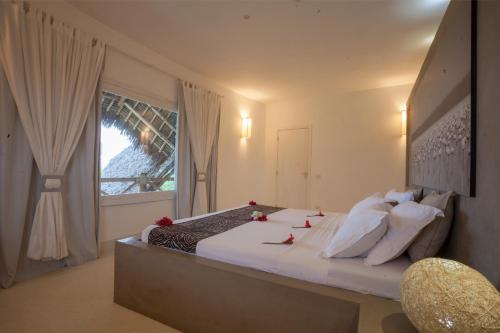 a bedroom with a large bed with a window at The Kasa Malindi in Malindi