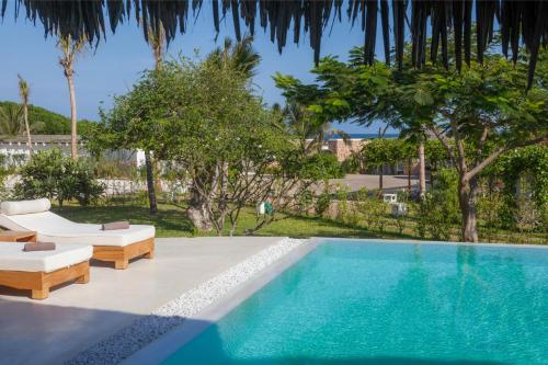 a swimming pool with two lounge chairs and a swimming pool at The Kasa Malindi in Malindi