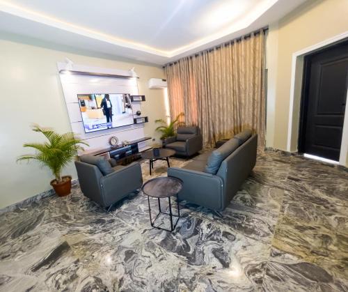 a living room with two couches and a tv at 154 Apartments and Hotel in Abuja