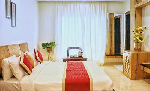 a bedroom with a large bed and a chair at Townhouse Bargi Hills Formerly Hotel Sharma in Jabalpur