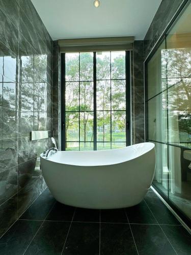 a bath tub in a bathroom with a large window at Biệt Thự chủ nhà tự doanh tại FLAMINGOS ĐẠI LẢI RESORT in Phúc Yên