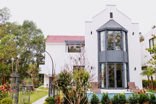 a white house with a cross on the roof at Biệt Thự chủ nhà tự doanh tại FLAMINGOS ĐẠI LẢI RESORT in Phúc Yên