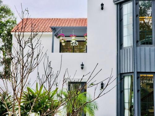 a white building with a window with flowers on it at Biệt Thự chủ nhà tự doanh tại FLAMINGOS ĐẠI LẢI RESORT in Phúc Yên