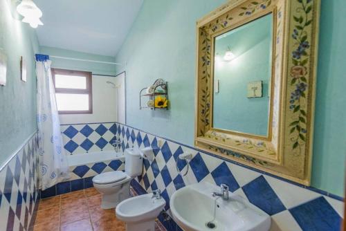 un bagno con due wc, un lavandino e uno specchio di Rural House with exclusive pool in Cordoba a Rivero de Posadas