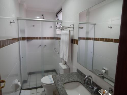 a bathroom with a toilet and a sink and a shower at Frimas Hotel in Belo Horizonte