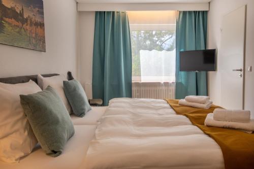 a large white bed in a room with a window at Hotel Clement - Bed & Breakfast in Ingelheim am Rhein