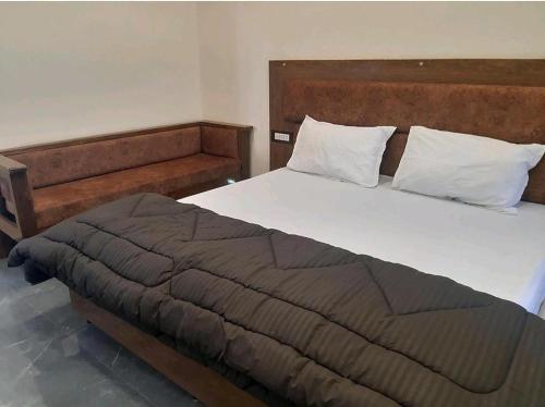 a bedroom with a large bed with white pillows at Hotel Sangam sagar in Sāgar