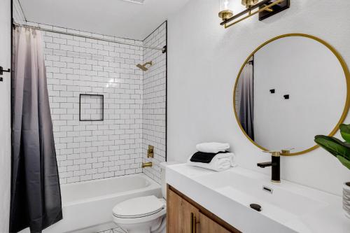 a white bathroom with a sink and a mirror at NEW! Luxe Vacation Retreat - heated pool, putting green in Peoria