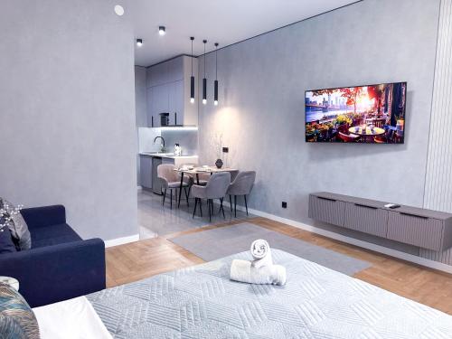 a living room with a tv hanging on a wall at Современный отдых в сердце города in Almaty