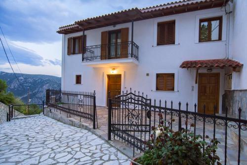a white house with a fence in front of it at Delphi View - 3 Bedrooms apartment, fully equipped in Delphi