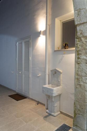 a bathroom with a sink in the corner of a room at Corte Maria in Castri di Lecce