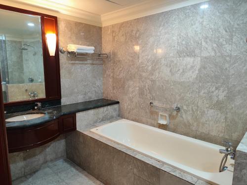 a bathroom with a bath tub and a sink at The Marvelous Suites at Times Square Kuala Lumpur in Kuala Lumpur