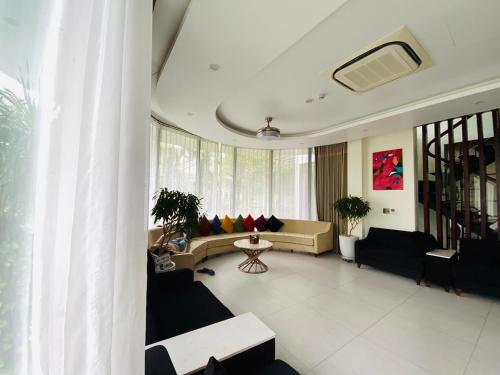 a living room with couches and a table at Biệt Thự chủ nhà tự doanh tại FLAMINGOS ĐẠI LẢI RESORT in Phúc Yên