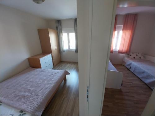 a small bedroom with two beds and a mirror at Sorin Apartments Gevgelija in Gevgelija