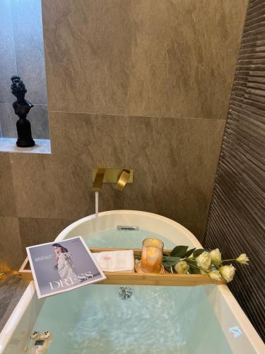 a bathroom with a bath tub with a book and candles at Browndot Hwagok in Seoul