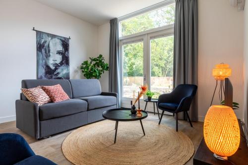a living room with a couch and a table at Spacious home, 10 min from Efteling in Tilburg